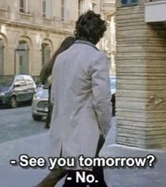 a man walking down the street in front of a tall building with a sign that says, see you tomorrow? no