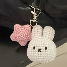 a crocheted bunny keychain with a pink rose on it's side