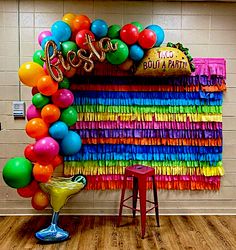 there is a party decoration with balloons and streamers in the shape of a rainbow