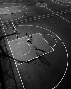 a person on a court with a basketball in the air and some hoops near by