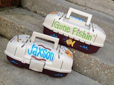 two plastic toy boats sitting on the ground next to each other, one is white and purple