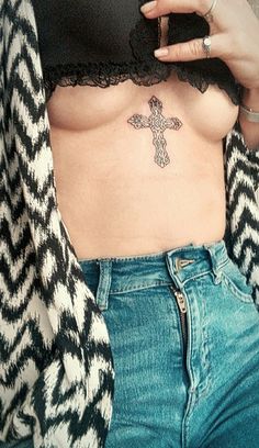 a woman with a cross tattoo on her stomach