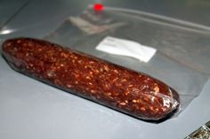 a long piece of food in a plastic bag on top of a metal countertop