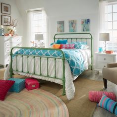 a bed room with a neatly made bed and colorful pillows