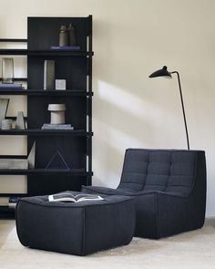 a living room filled with furniture and a book shelf next to a lamp on top of a table