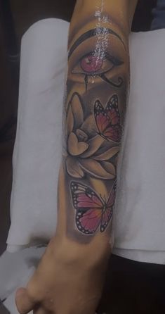 a woman's arm with tattoos on it and butterflies in the middle of her arm