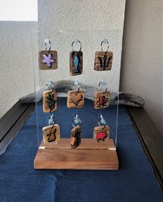 a display case with wooden stamps and magnets in it on a blue table cloth