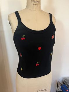 Cute summery cropped tank top embroidered with small fruit motifs - watermelon, cherry, strawberry, and pineapple. Made from a super soft and stretchy cotton/poly blend. Color: black Size pictured: L (on size 4 dress form) Please note: there was a small tear in the tank top that I was mostly able to cover with the pineapple embroidery, but some stitches are still visible on the right - see detail photo. Fitted Fruit Print Summer Tops, Cute Black Summer Crop Top, Cute Black Crop Top For Summer, Cute Sleeveless Top With Strawberry Print, Cute Sleeveless Strawberry Print Top, Summer Sleeveless Top With Cherry Print, Casual Sleeveless Top With Strawberry Print, Sleeveless Top With Cherry Print For Summer, Sleeveless Cherry Print Top For Summer