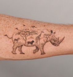 an arm with a rhino and birds on it