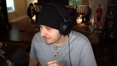 a young man wearing headphones while sitting in front of a computer