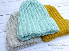 three crocheted dishcloths sitting on top of each other in different colors