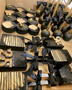 there are many black and gold boxes on the table with decorative items in them for sale