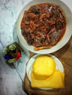 a bowl of stew next to two plates of food