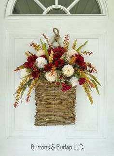 a basket filled with flowers sitting on top of a door