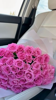 a bouquet of pink roses sitting in the back seat of a car