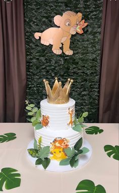 there is a cake that has been decorated with animals and leaves on the top tier