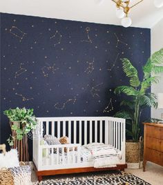 a baby's room with stars painted on the wall and a white crib