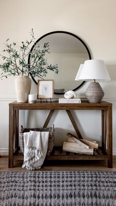 a wooden table topped with a mirror next to a lamp