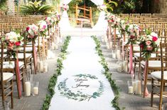 the aisle is decorated with flowers and greenery