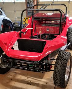 a red four wheeled vehicle parked in a garage