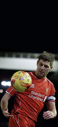 a soccer player in action with the ball on his head and one hand holding it