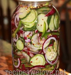 a jar filled with sliced cucumbers and red onions