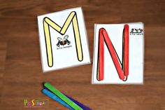 the letter m worksheet is next to scissors and colored pencils on a wooden table