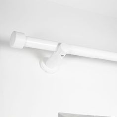 a white toilet paper dispenser hanging on the wall next to a roll of toilet paper