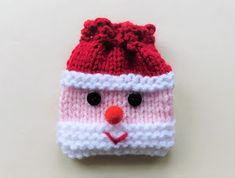 a red and white knitted hat with a face