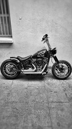 a black and white photo of a motorcycle parked in front of a building