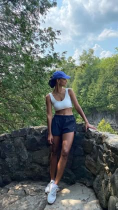 a woman standing on top of a stone wall