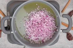 chopped red onions are being cooked in a pot