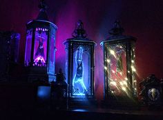 three lit up lanterns sitting next to each other