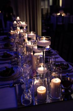 a long table is set with candles and plates