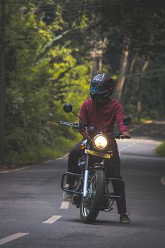 a man riding on the back of a motorcycle down a road