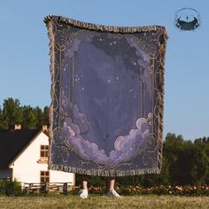 a woman standing in front of a large purple blanket with clouds and stars on it