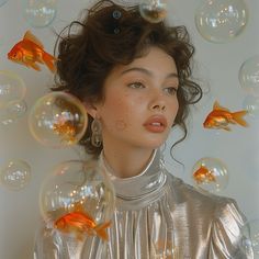 a young woman is surrounded by bubbles and goldfish in this image, she has her eyes closed