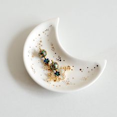 a white plate with some gold and green beads on it