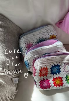 three crocheted bags sitting on top of a bed