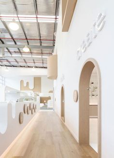 the inside of a building with wooden floors and white walls