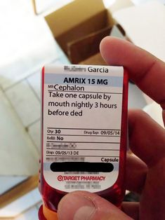 a person holding up a medicine bottle with the label labeled amritx 15mg