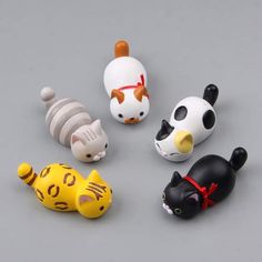 small plastic animal figurines sitting on top of a gray surface with white and black cats