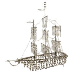 a metal ship with lots of beads hanging from it's sails