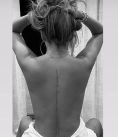 the back of a woman's body with tattoos on her upper and lower back