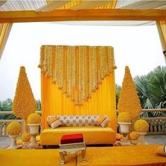 a decorated stage with yellow drapes and pillows