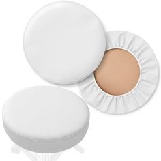 two white round cushions and one with a light tan colored powder on the top, sitting next to each other