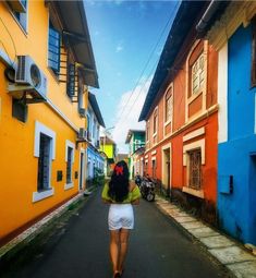 a woman walking down the street in front of colorful buildings