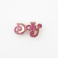 a pair of pink and gold broochies with the word doub written in cursive writing