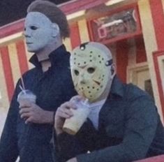 two people wearing masks standing next to each other