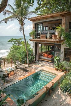 an outdoor swimming pool surrounded by palm trees and greenery next to the ocean with a house in the background